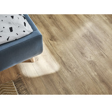 Lichte laminaatvloer in woonkamer met blauwe fauteuil