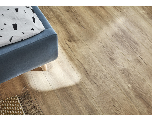 Lichte laminaatvloer in woonkamer met blauwe fauteuil