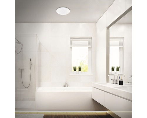 Lichte badkamer met bad, douche, wastafel en plafondlamp