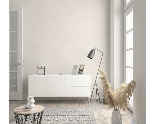 Woonkamer met wit dressoir, staande lamp, tapijt en decoratie