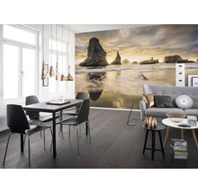 Woonkamer met fotobehang van een kustlandschap, een eettafel en een bank.