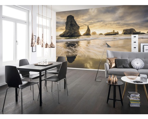 Woonkamer met fotobehang van een kustlandschap, een eettafel en een bank.