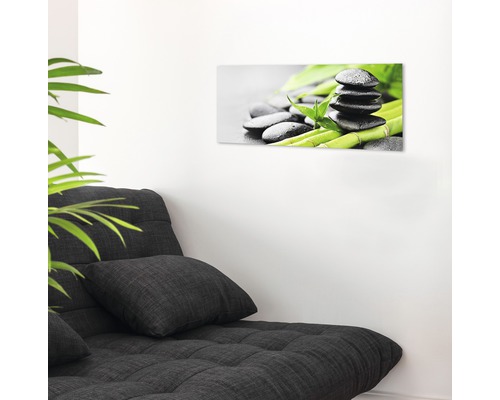Decoratieve glazen print met zenmotief boven een bank