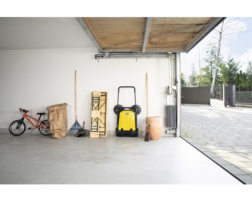 Garage met veegmachine, gazonhark, kinderfiets en bloempotten