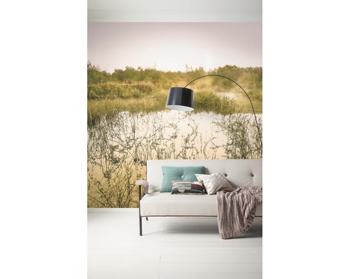 Woonkamer met bank, lamp en fotobehang met landschapsmotief