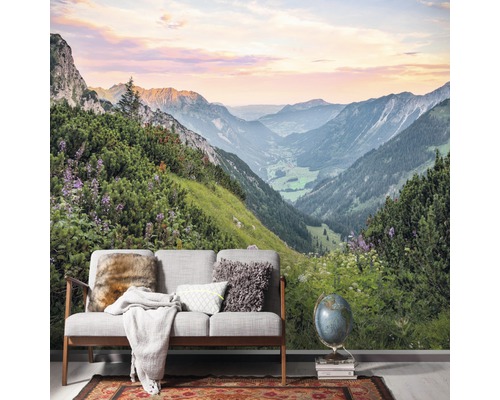 Fotobehang met berglandschapmotief achter een bank