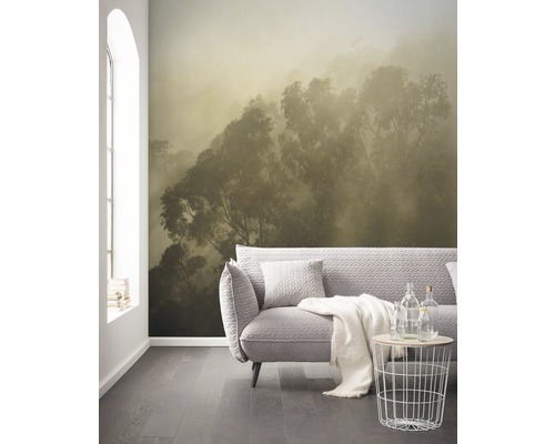 Woonkamer met fotobehang van een bos in de mist, bank en bijzettafel.