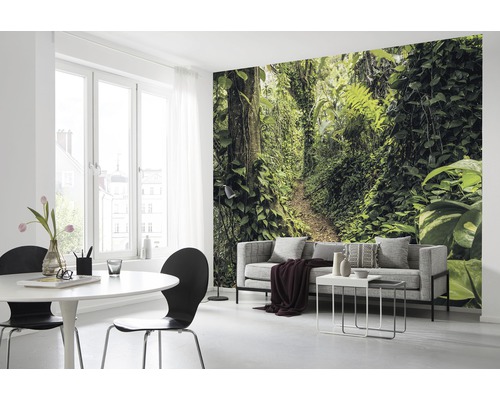 Woonkamer met fotobehang van een junglepad, bank en eettafel.
