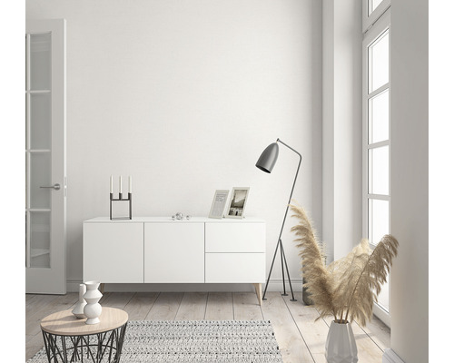 Lichte woonkamer met dressoir, staande lamp en decoratieve artikelen