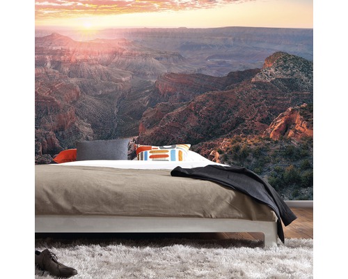 Slaapkamer met foto van een canyon bij zonsopgang op de muur
