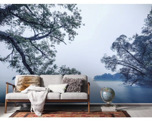 Woonkamer met fotobehang met bos- en zeemotief, bank, globe en tapijt