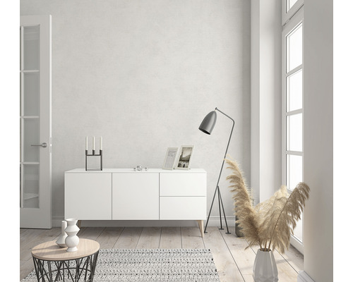 Lichte woonkamer met wit dressoir, staande lamp en decoraties.