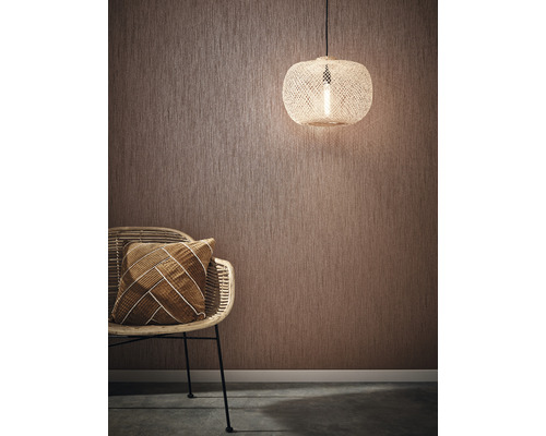 Kamerweergave met gestructureerd behang, rotan stoel, kussen en hanglamp