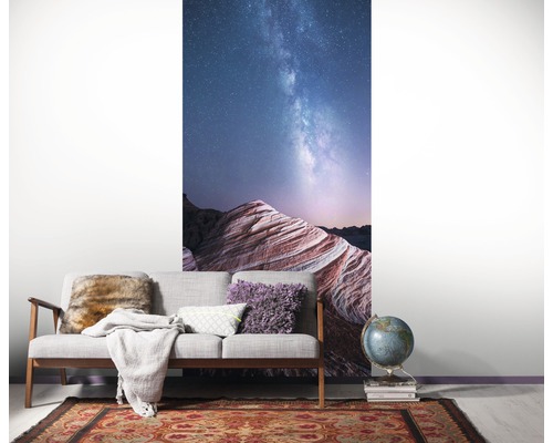 Woonkamer met een fotobehang van een landschap onder de sterrenhemel.