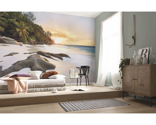 Woonkamer met foto van strandmotief, zitmogelijkheid en houten dressoir