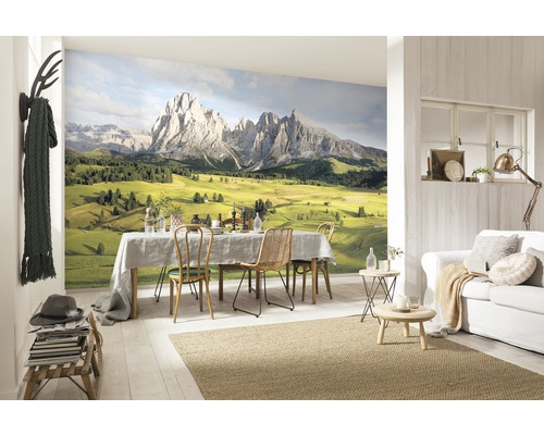 Woonkamer met fotobehang van een bergpanorama, eettafel, bank en decoraties