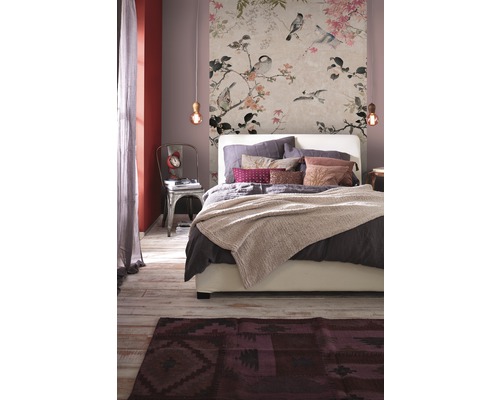 Slaapkamer met bloemenbehang, bed en vloerkleed