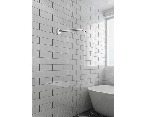 Badkamer met muurarm voor bad en witte tegels