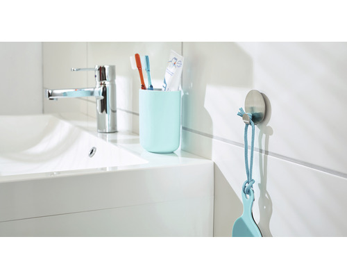 Badkamer wastafel met kraan, tandenborstelbeker met tandenborstels en haak met badkameraccessoire
