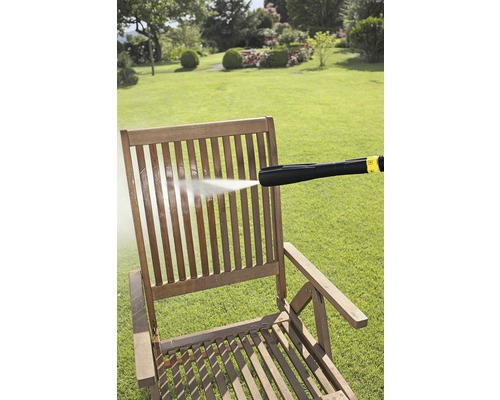 Houten stoel wordt gereinigd met een hogedrukreiniger in de tuin.