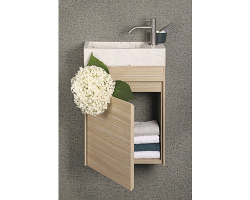 Wastafel met marmeren blad, kraan en open houten onderkast met handdoeken