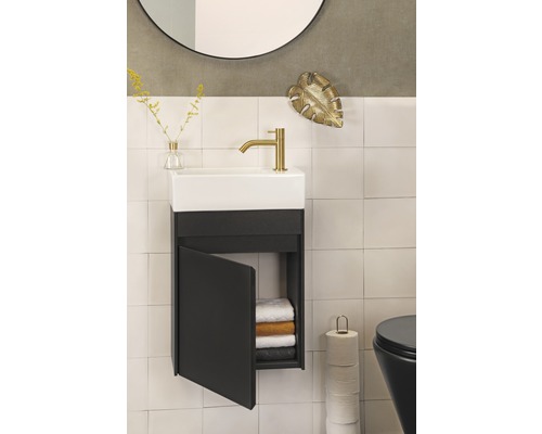 Badkamer met wastafel, onderkast met open deur, handdoeken, toilet, spiegel en decoratie