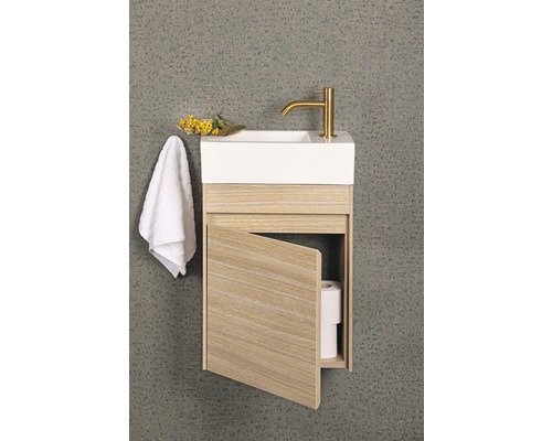 Kleine wastafel met open houten kast, handdoek en kraan