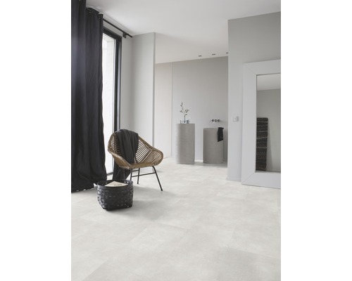 Lichte badkamer met designvloer in tegellook, rotan stoel en zwart gordijn