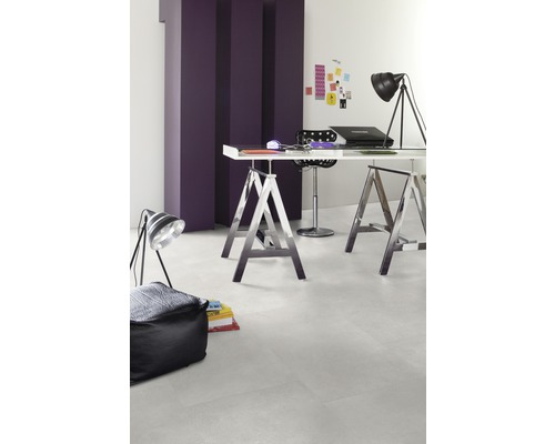 Lichte werkruimte met bureau op schragen, staande lamp en zitkussen