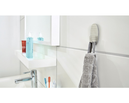 Badkamer met wastafel, spiegel en handdoekhaak met handdoek
