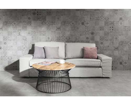 Woonkamer met bank, kussens, tafel en wandtegel met patroon