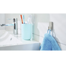 Lichte badkamer met wastafel, tandenborstelbeker, handdoekhaak en blauwe handdoek