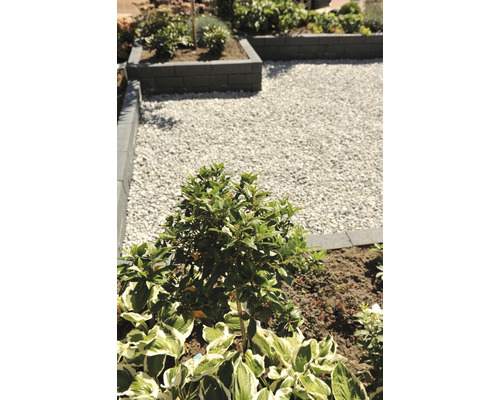 Aangelegde tuin met grindpad, plantenbedden en opsluitbanden