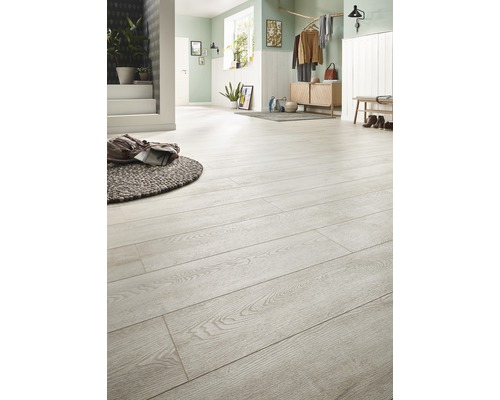 Lichte entree met lichte houten vloer, dressoir en bank