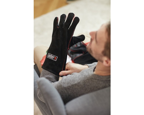 Man trekt Weber barbecuehandschoenen aan