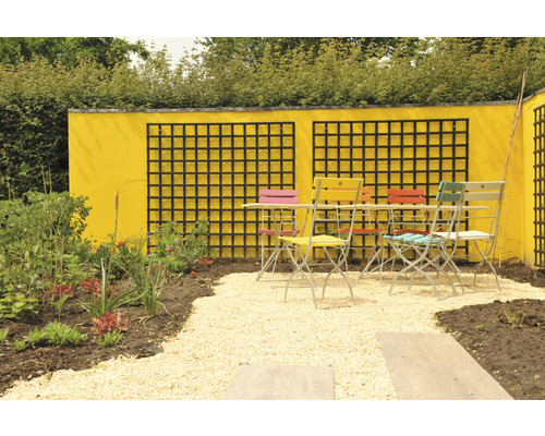 Tuinscène met tafel, stoelen, gele muur en planten