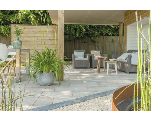Terras met tuinmeubelen, planten en houten schutting