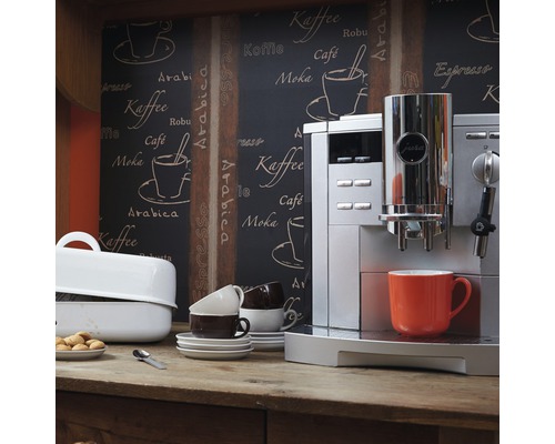 Scene met een Jura volautomatische koffiemachine, kopjes en gebak op een houten tafel