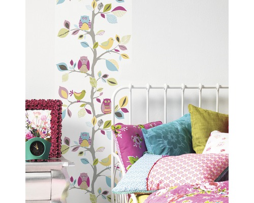 Lichte slaapkamer met bed, nachtkastje en behang met boom-, vogel- en uilmotieven