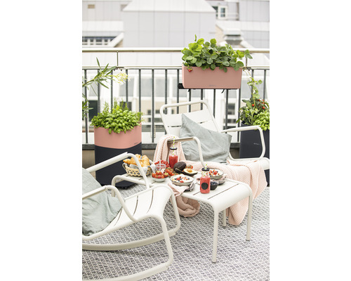 Balkonscène met tafel, stoelen en beplante plantenbakken