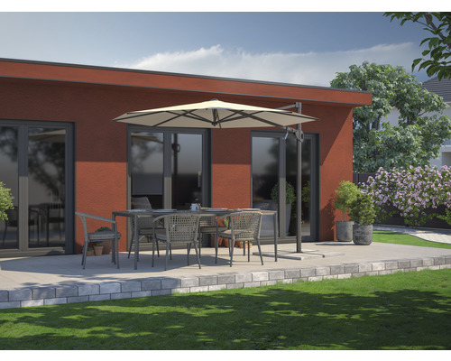 Terras met eettafel, stoelen en parasol voor een huis.