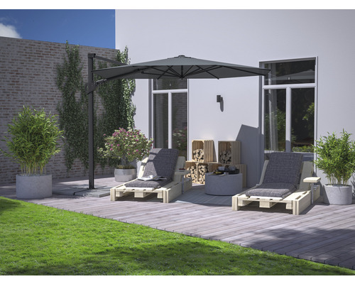 Tuinscene met twee houten ligstoelen, parasol, houten kisten, planten en gazon