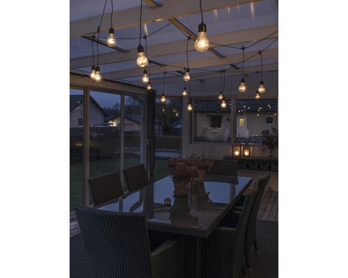 Terras met tafel, stoelen en lichtsnoer voor een sfeervolle ambiance.