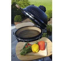 Keramische barbecue met grillrooster en groenten op een snijplank