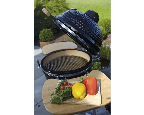 Keramische barbecue met grillrooster en groenten op een snijplank