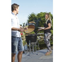 Buitenscène met een keramische barbecue, twee personen en tuindecoratie.
