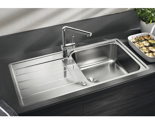 Roestvrijstalen spoelbak met afdruiprek en kraan op een werkblad