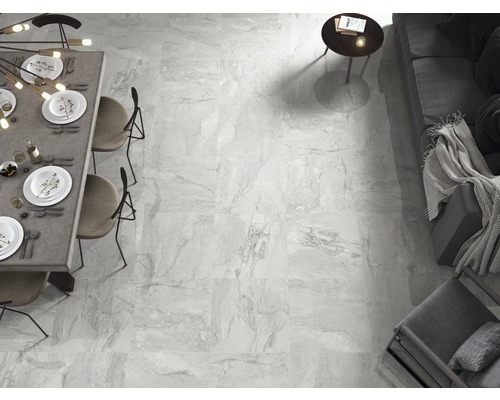 Lichte, betegelde woonruimte met eettafel en zitgelegenheid.