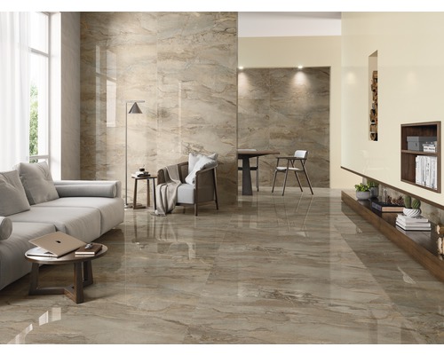 Lichte woonkamer met vloertegels in marmerlook, bank, tafel en stoel.