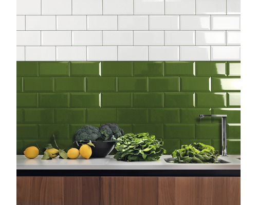 Keukenachterwand met witte en groene metro tegels boven een aanrecht met groenten